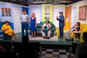 Theater performers act on a bright stage set with colorful walls and furniture.