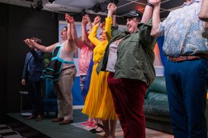 Theater cast members take a bow at the end of their performance on stage.