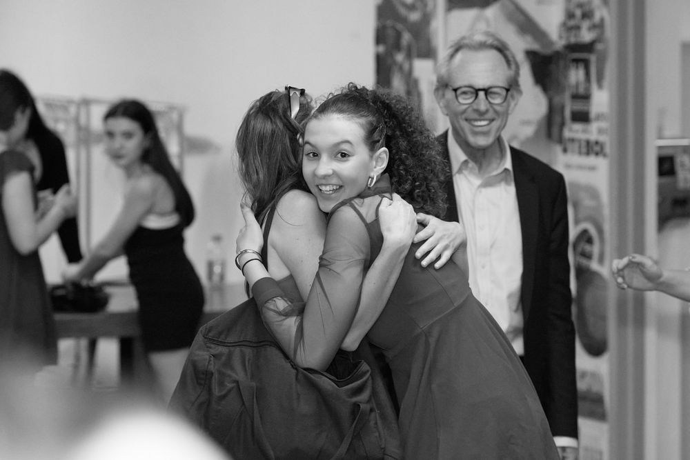 Bat Mitzvah girl hugs guest with joy during Brooklyn rooftop celebration. Emotional moment captured by George Robert Photography.