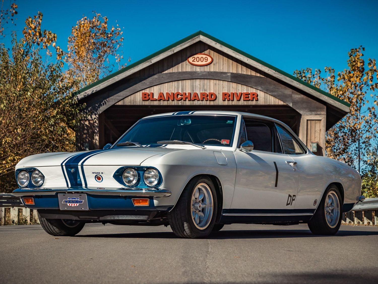 Classic silver BMW 2002 car parked in front of Blanchard River building.