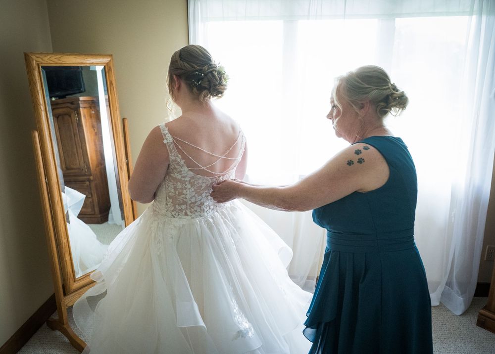 A series of shots showing wedding dress preparations with attendants helping the bride get ready in a sunlit room.