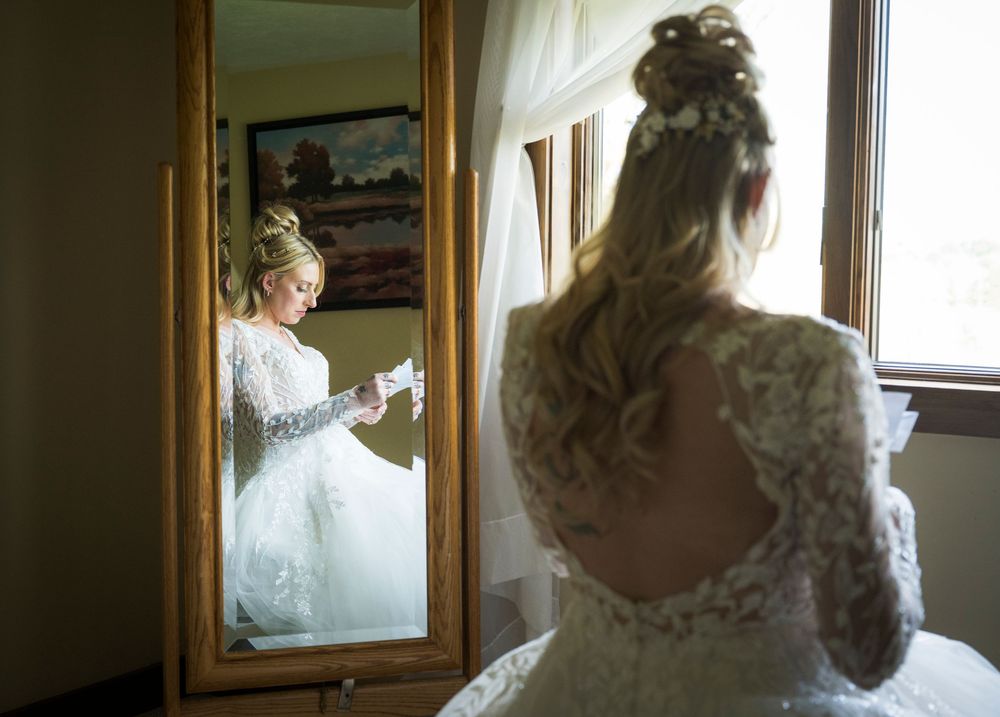 Reflection of bridal gown in mirror with delicate lace details.