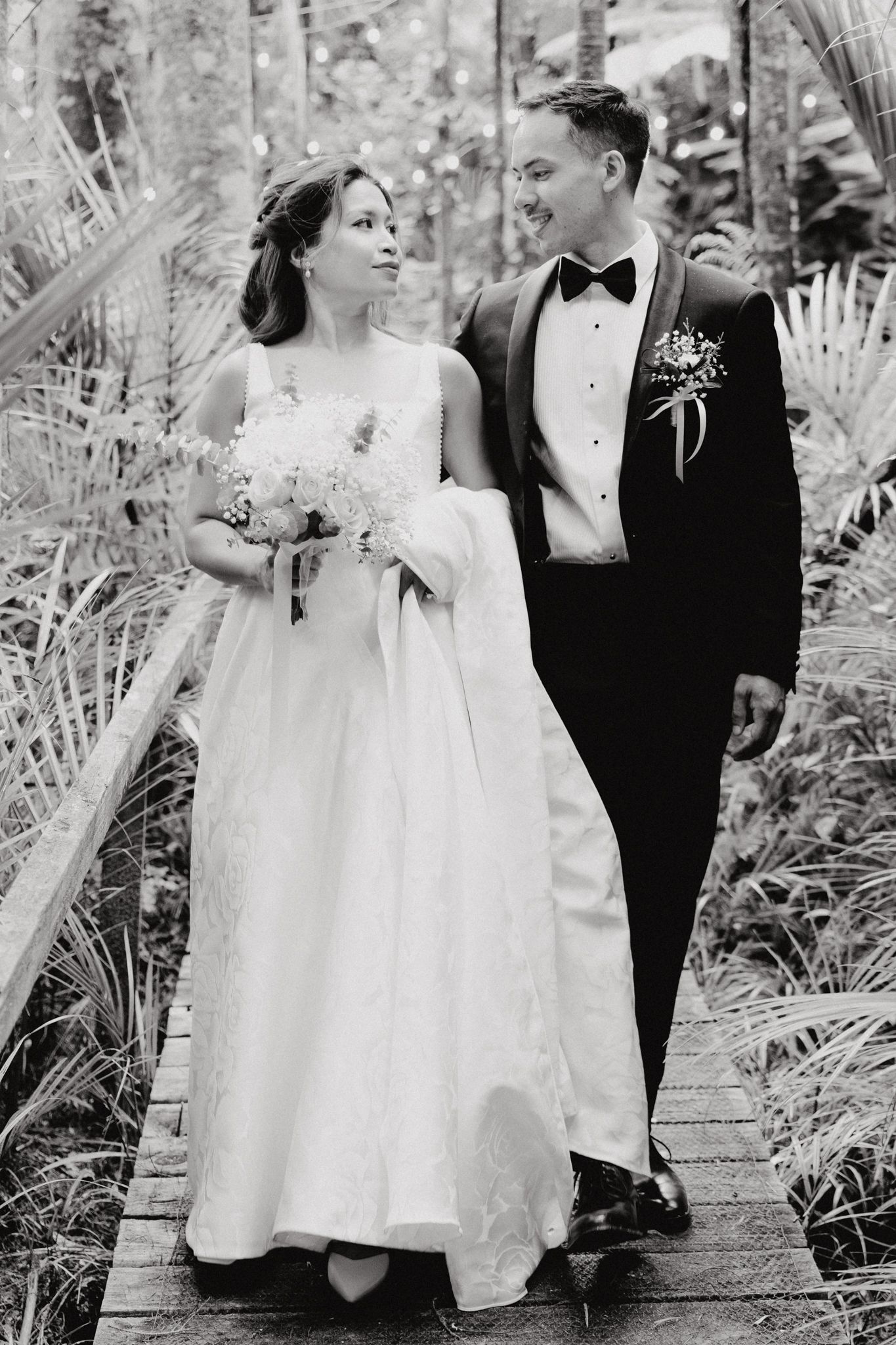 A bride and groom share a joyful moment while walking together captured by Apertured Media Auckland Wedding Photographer.