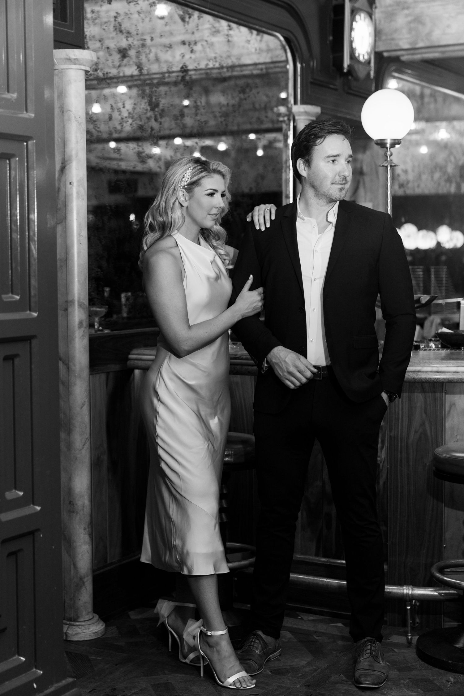 Black and white portrait in classic bar interior with vintage lighting fixtures. Engagement Session at The Lafayette Hotel in San Diego.