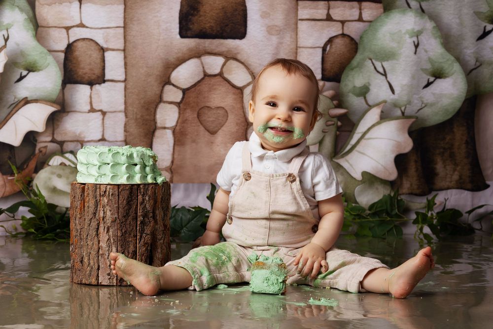Whimsical woodland-themed studio setup with castle backdrop, tree stump and green leaves for spring photography.