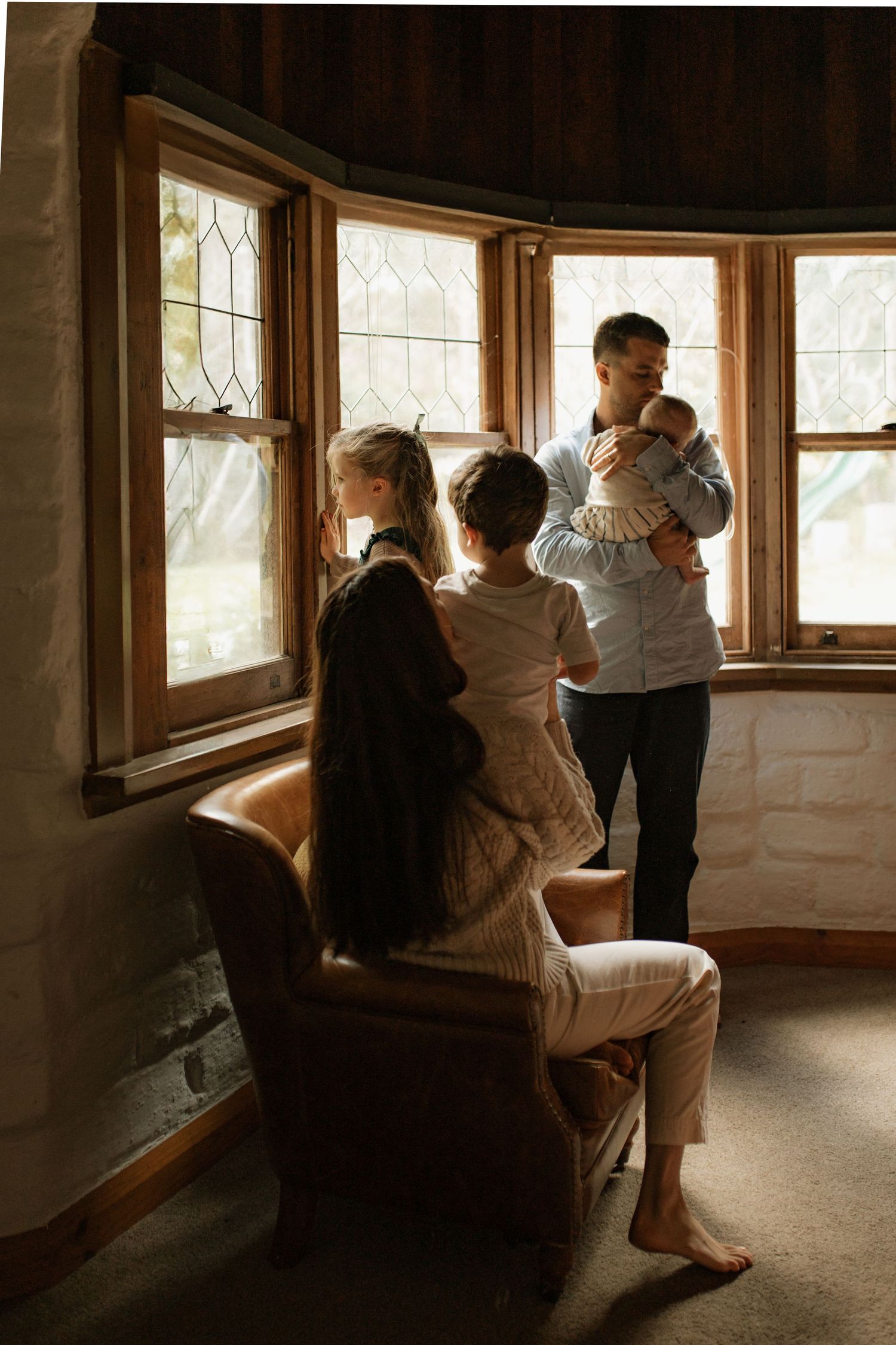Storytelling photograph of mother and her family in their family home interacting with each other