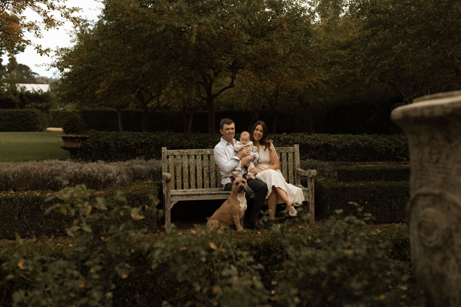 Family photograph sitting on a garden bench holding hands