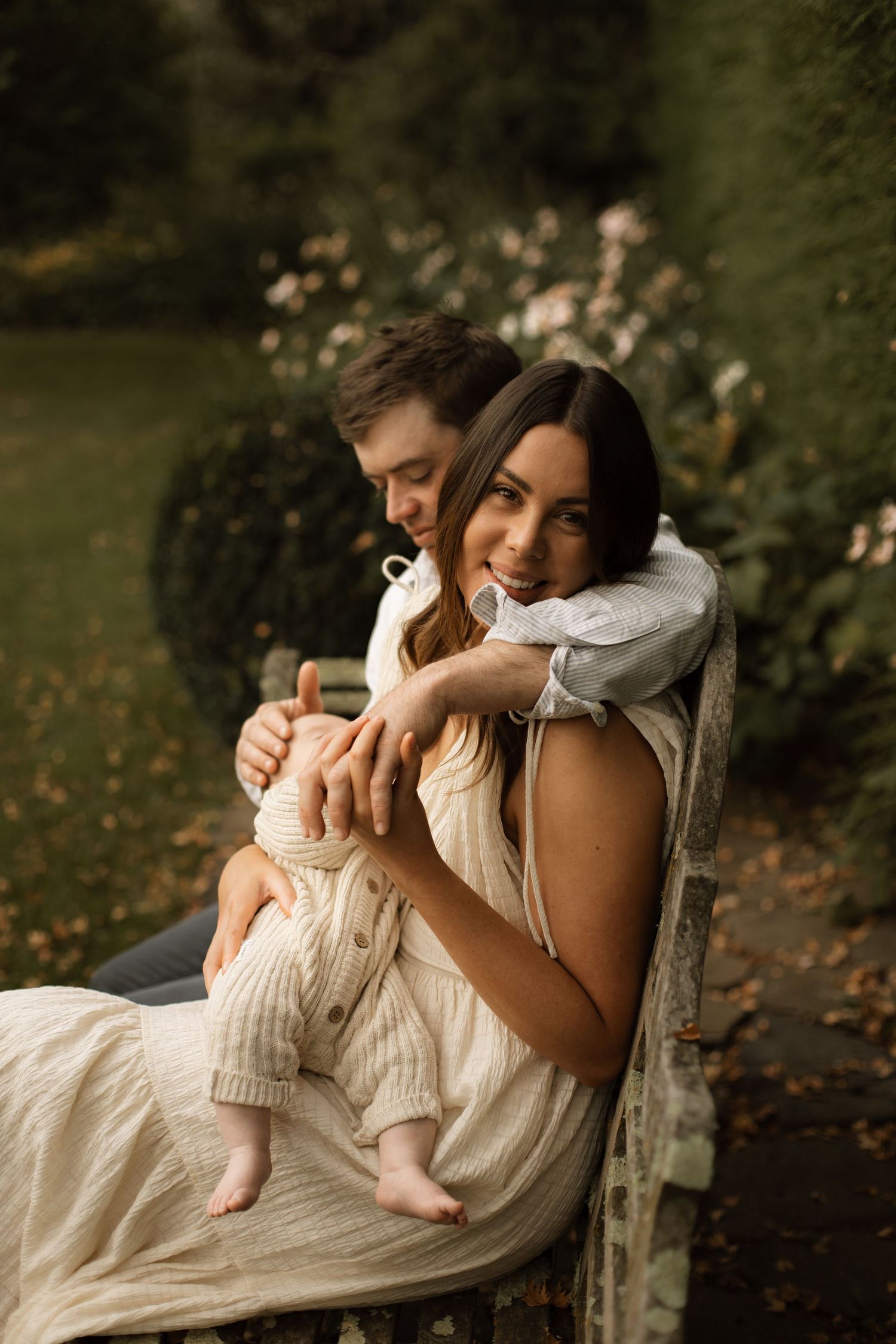 Family photograph sitting on a garden bench holding hands