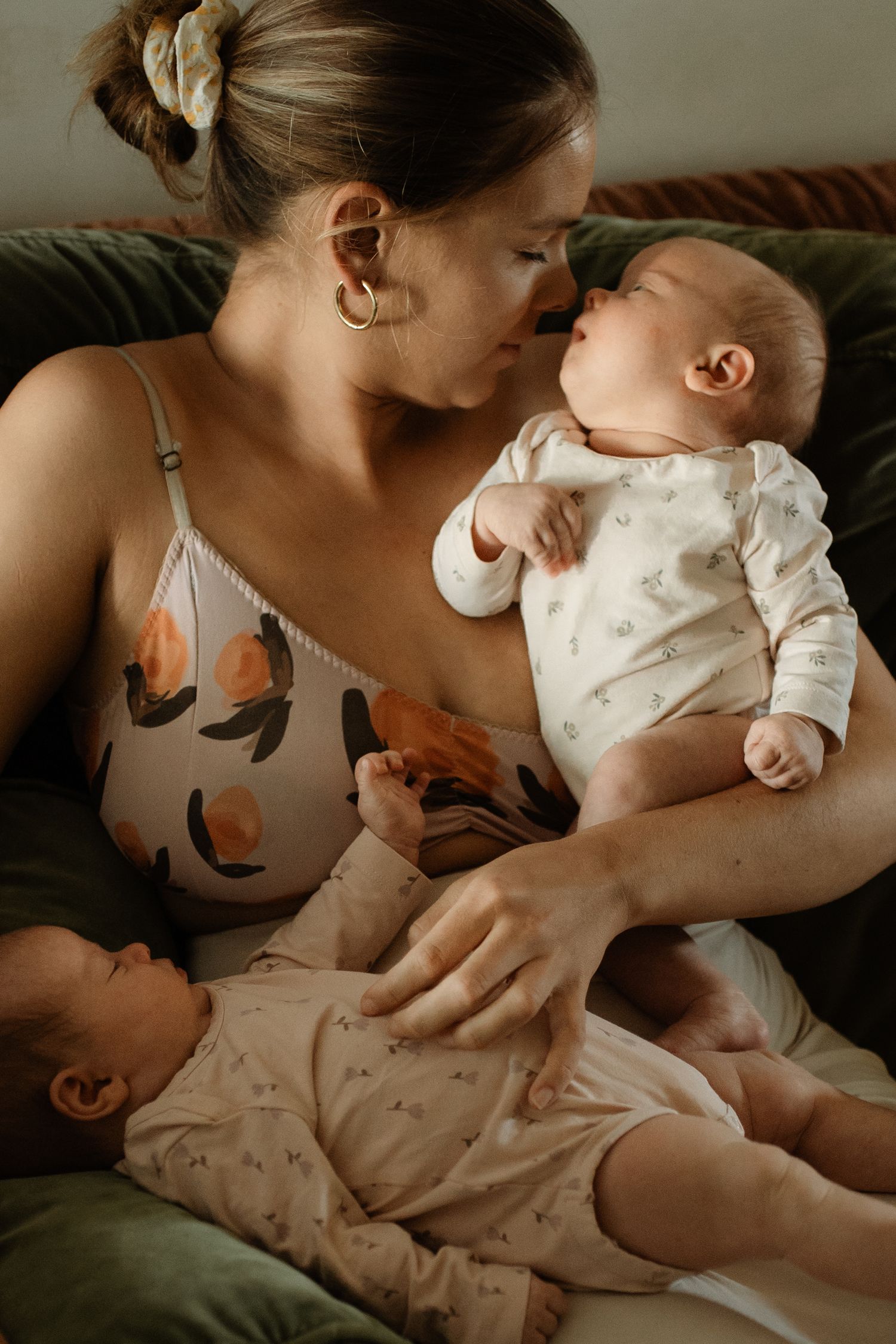 Mother cuddling her twin baby girls