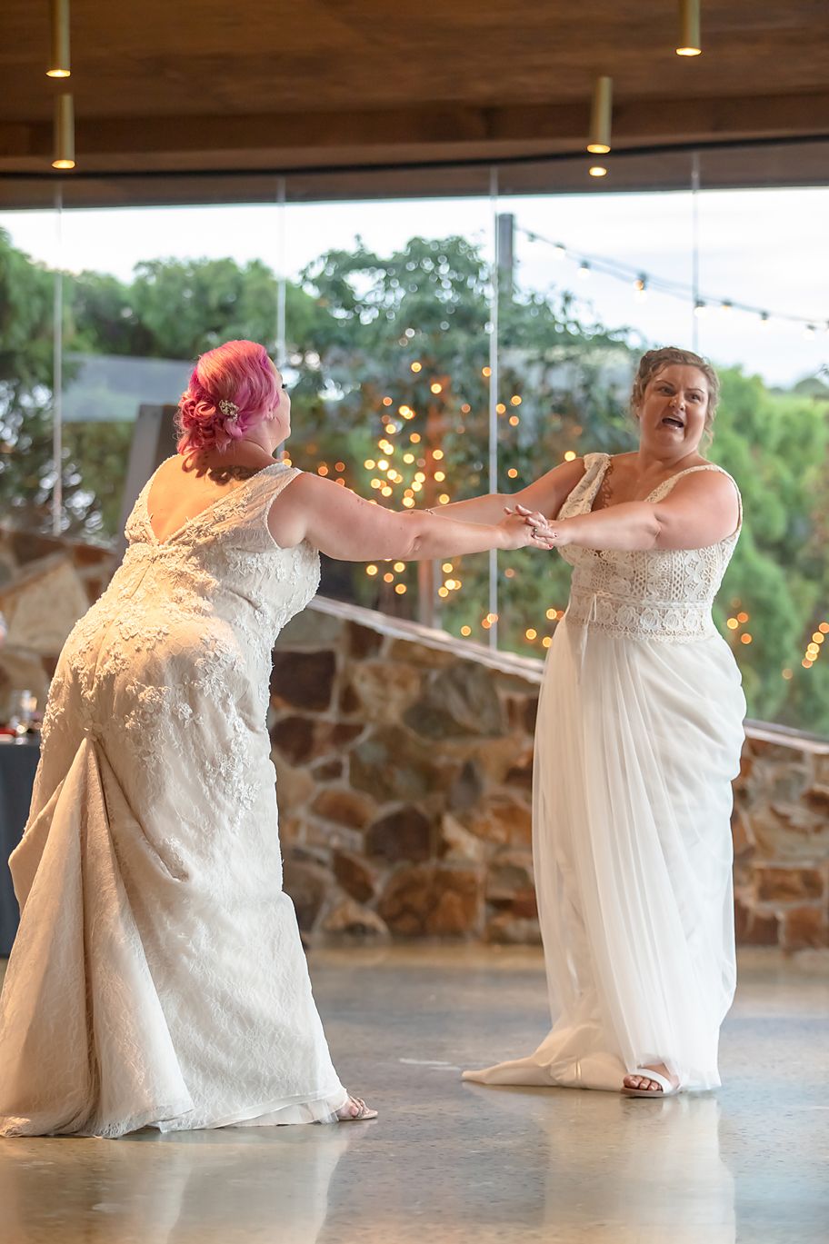 Composite photo sequence showing a bride in a white dress twirling and dancing on a stone patio with string lights at dusk.