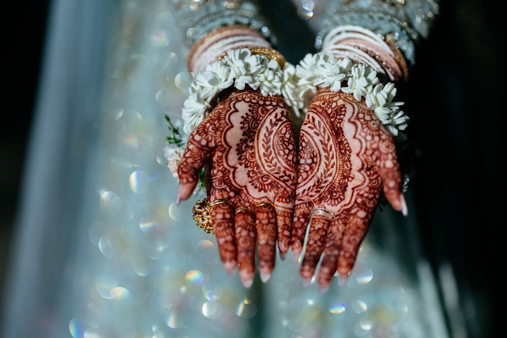 Detailed traditional henna design adorns palms during a wedding celebration.