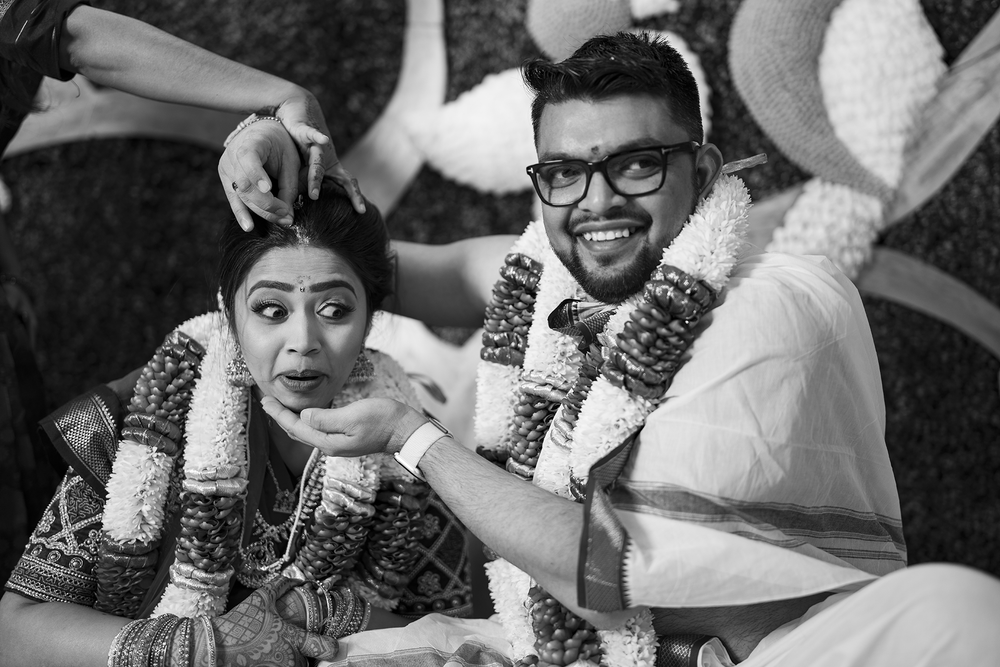 Three black and white photos showing hands being decorated with intricate henna designs and bangles on wrists.