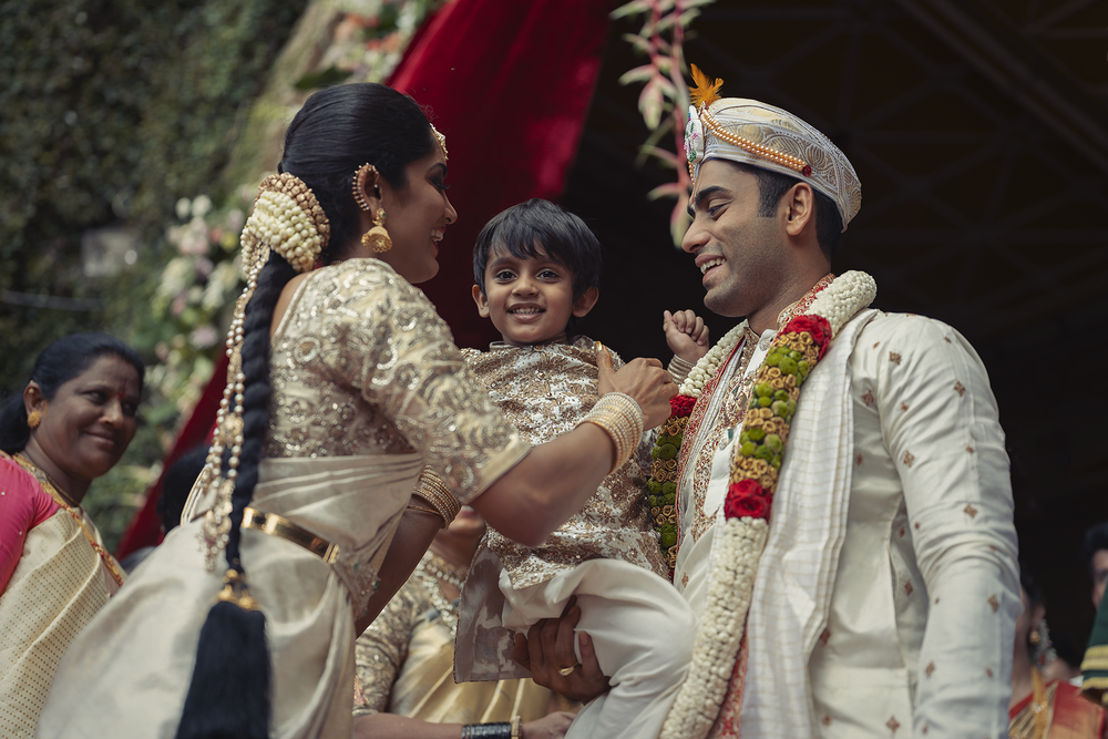 Couple in traditional Indian wedding attire exchange smiles during their traditional marriage ceremony.