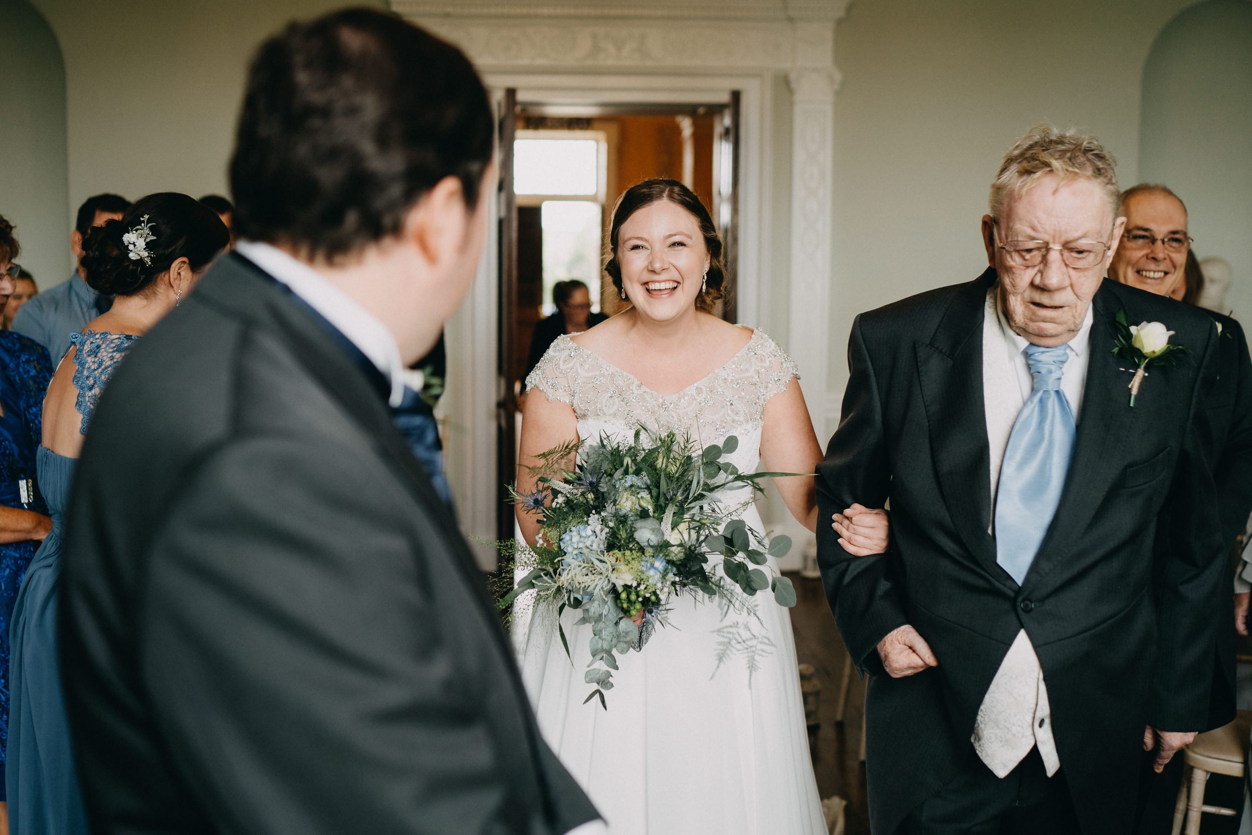 A joyous moment captured during a formal ceremony in an elegant white-walled interior.