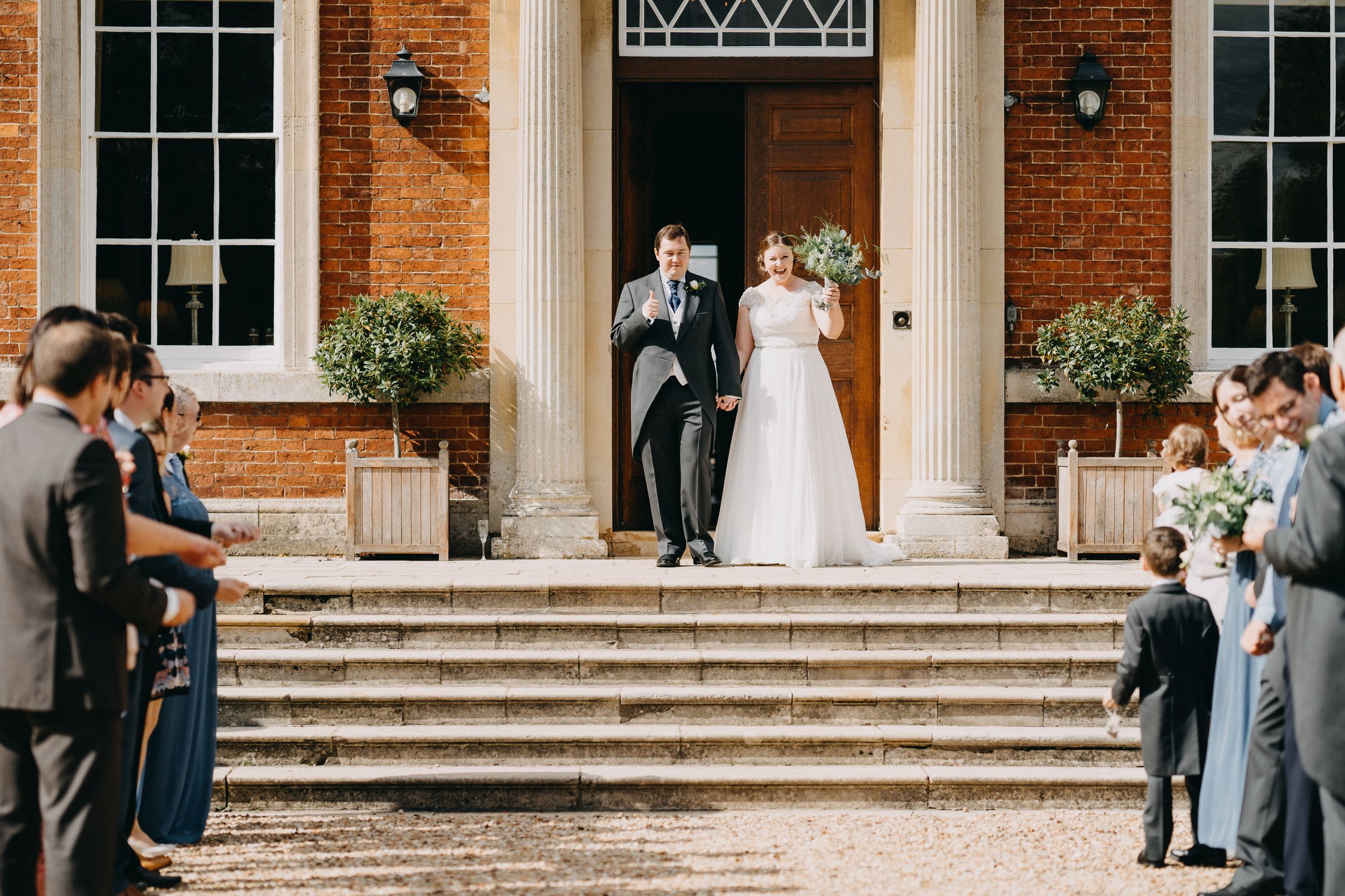 A celebratory wedding moment on the steps of a beautiful brick mansion.