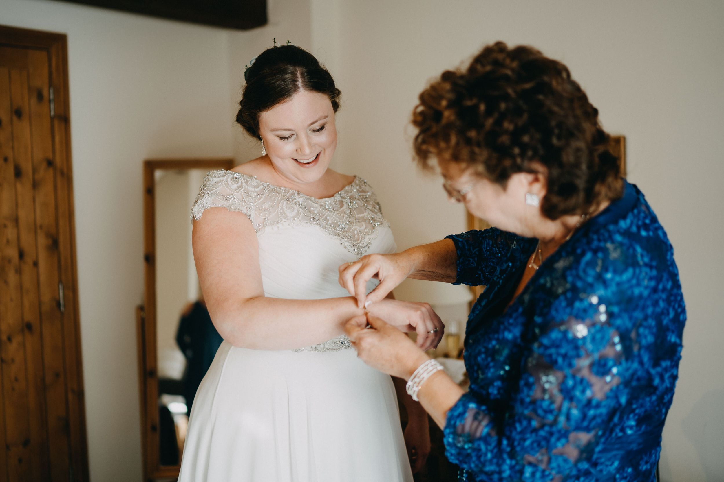 Wedding preparation moment with blue sequined dress and white lace gown.