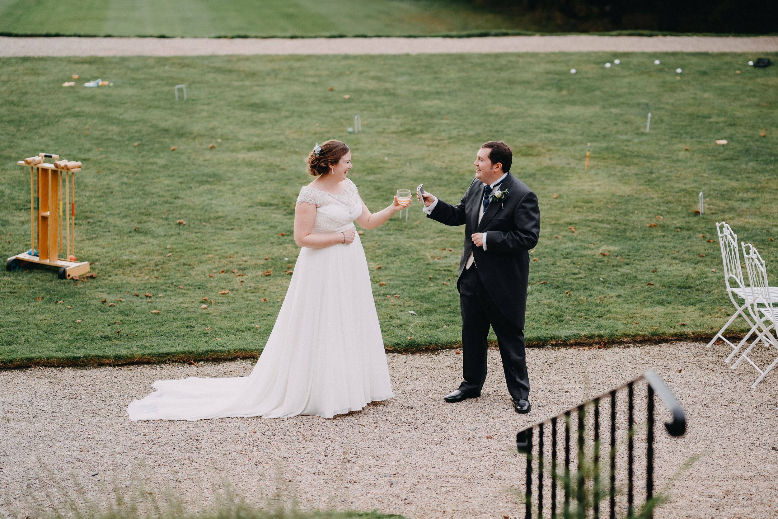 Wedding couple toasting with champagne on the garden grounds.