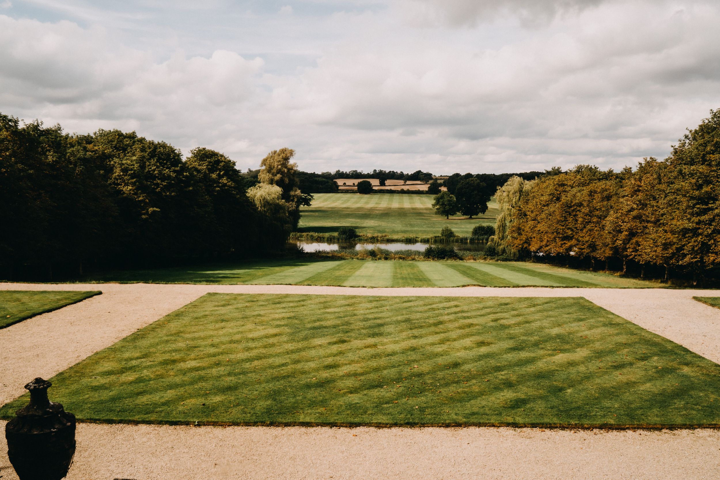 Expansive manicured lawn at Kelmarsh Hall with curved pathways leading to distant countryside views.