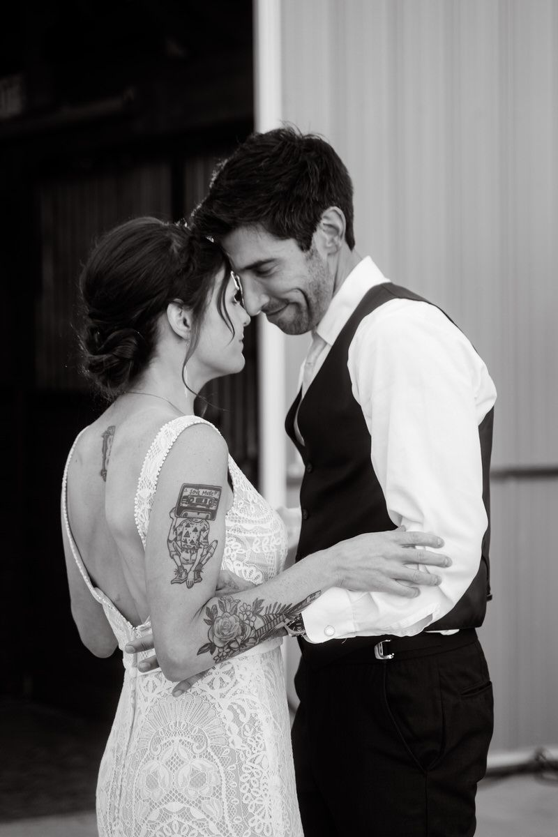 A black and white photo of the bride and groom at the end of the first dance during this backyard wedding in South Haven, Michigan.