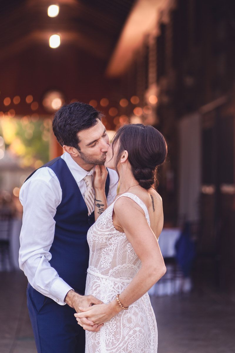 The bride and groom kiss at the end of the first dance during this backyard wedding in South Haven, Michigan.