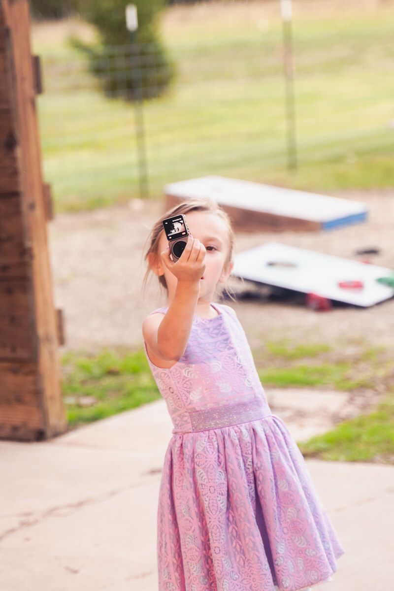 A young wedding guest films herself with a professional action camera for a DIY wedding reception event in Southwest Michigan.