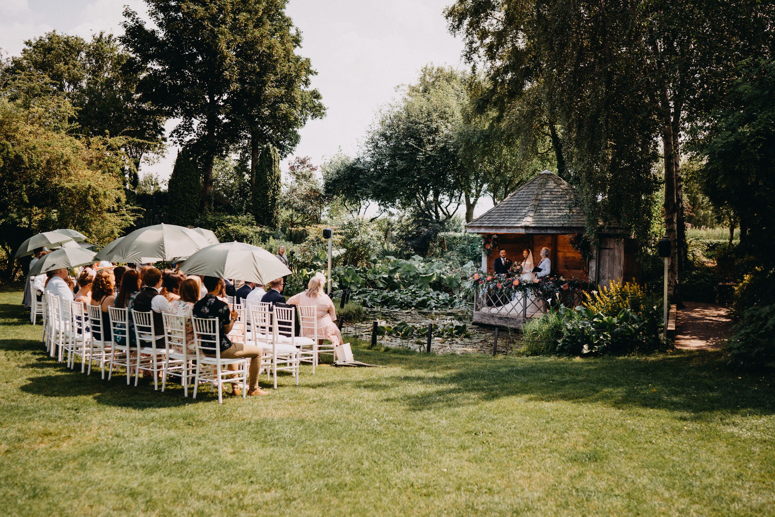 Garden wedding setup at South Farm with white umbrellas and chairs on a sunny afternoon.