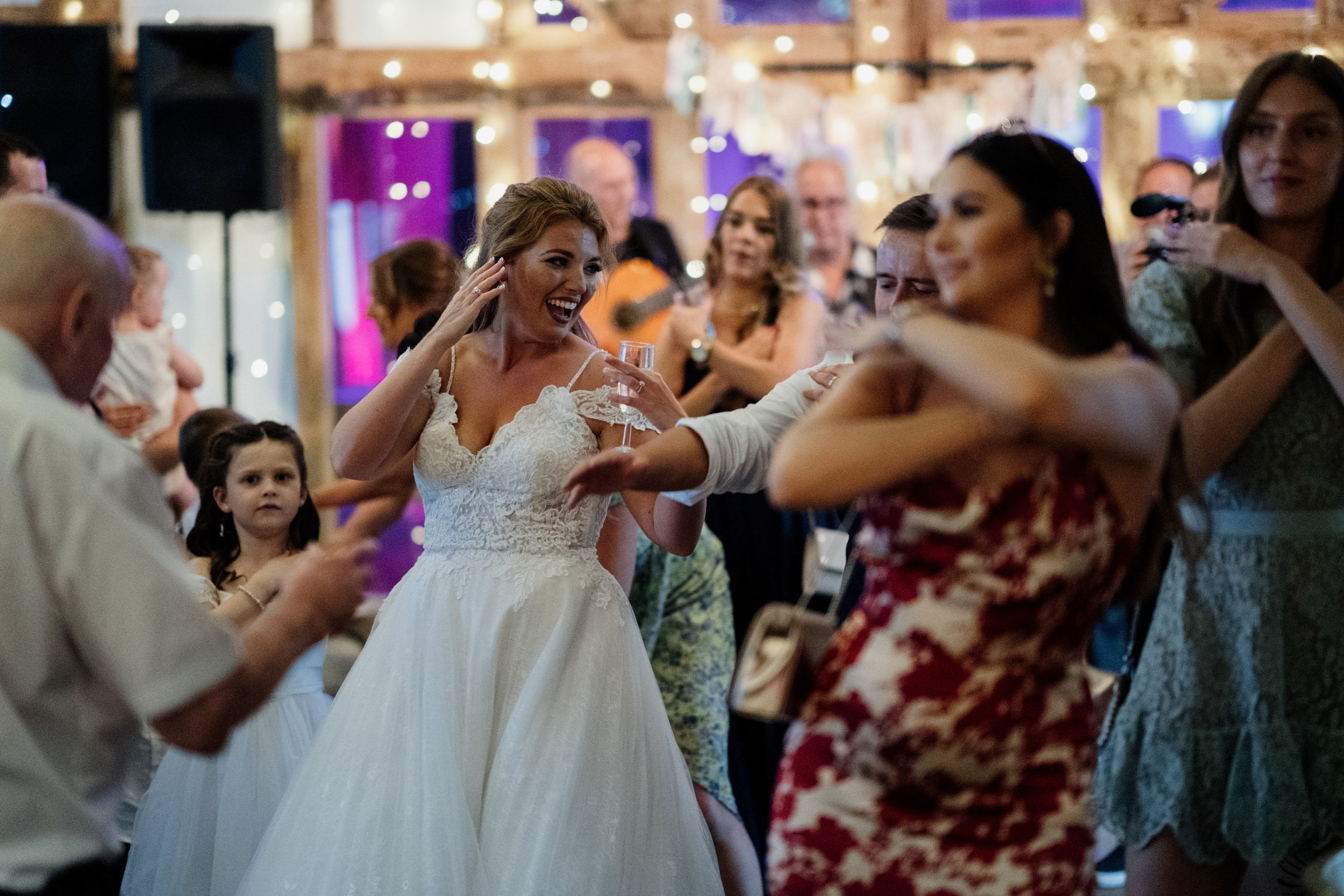 Wedding reception dance floor filled with guests enjoying animated celebration.