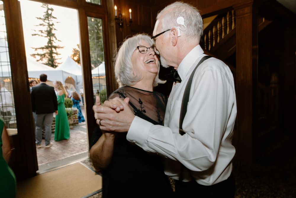 An elderly couple sharing a tender dance moment at a wedding reception.