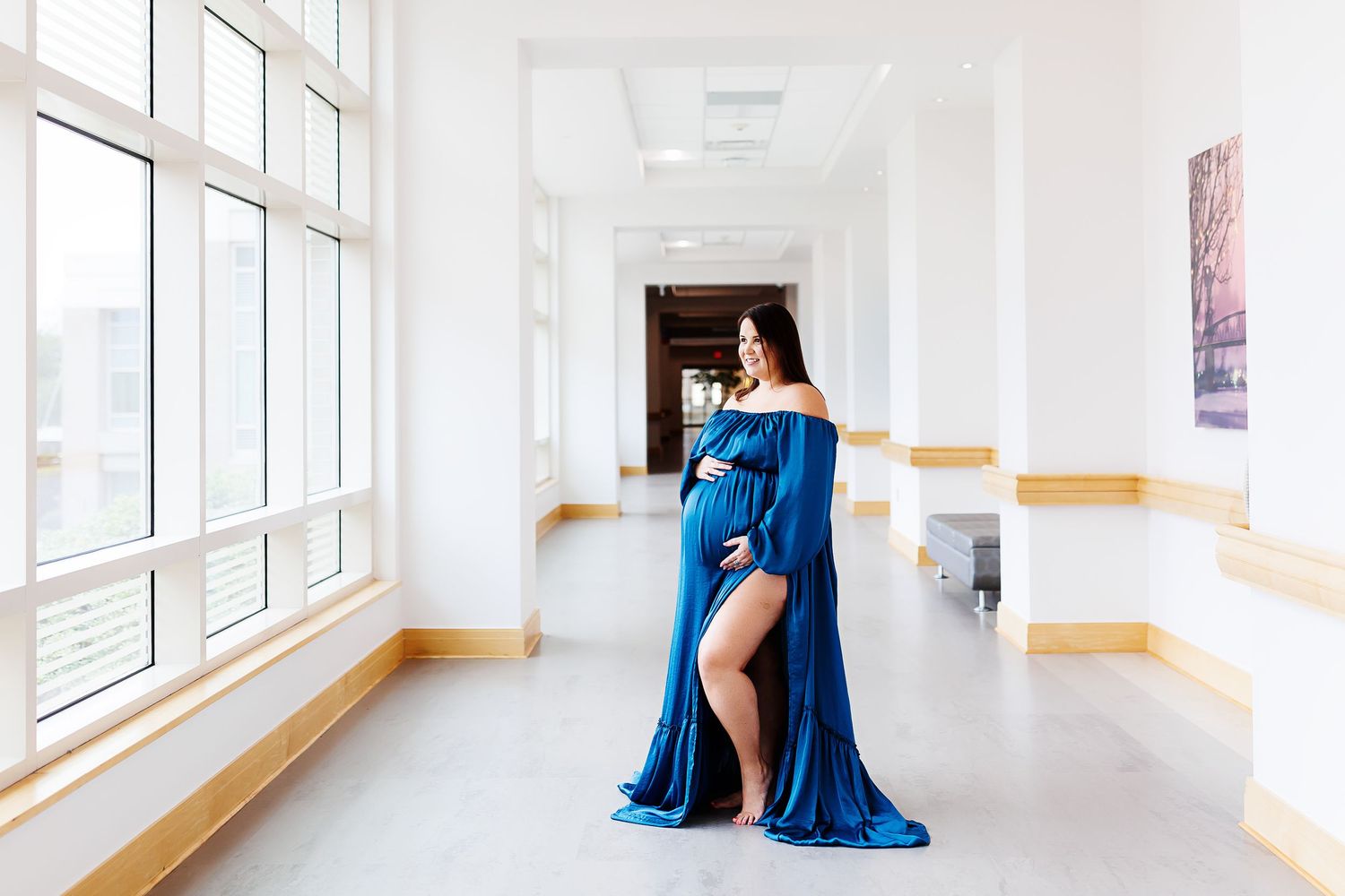 A blue maternity gown in a bright white hospital hallway, just before birth.Maternity session captured by Samantha Ann Photography