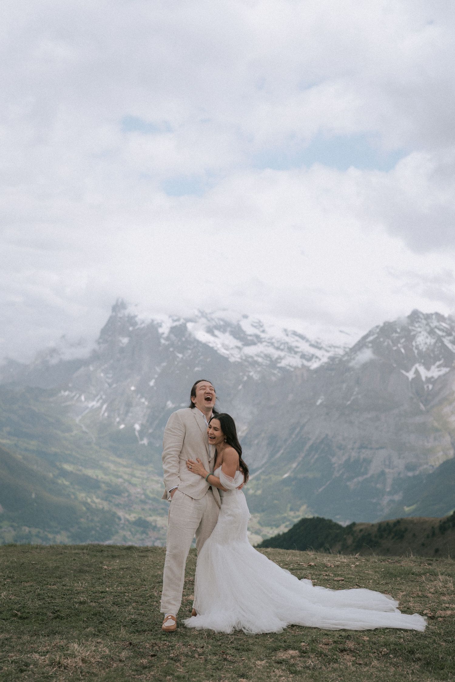 A couple kissing with a stunning mountain backdrop as they celebrate their engagement.