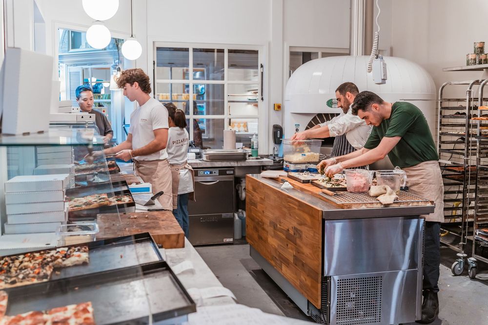 Workers making pizza at Hay St market in Sydney. © SIX84 Photography