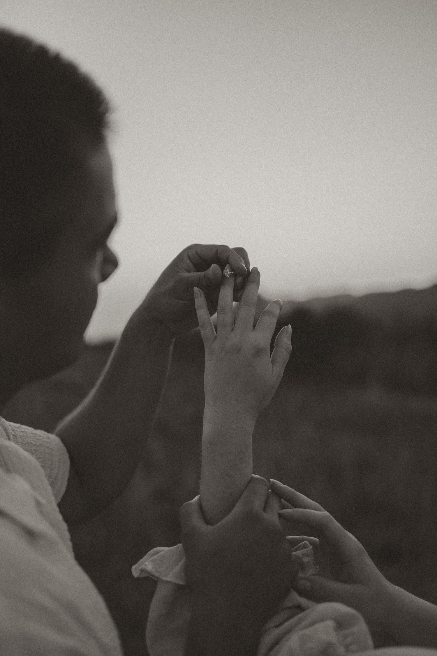 A black and white sequential montage shows a hand raising upward against a dark background.