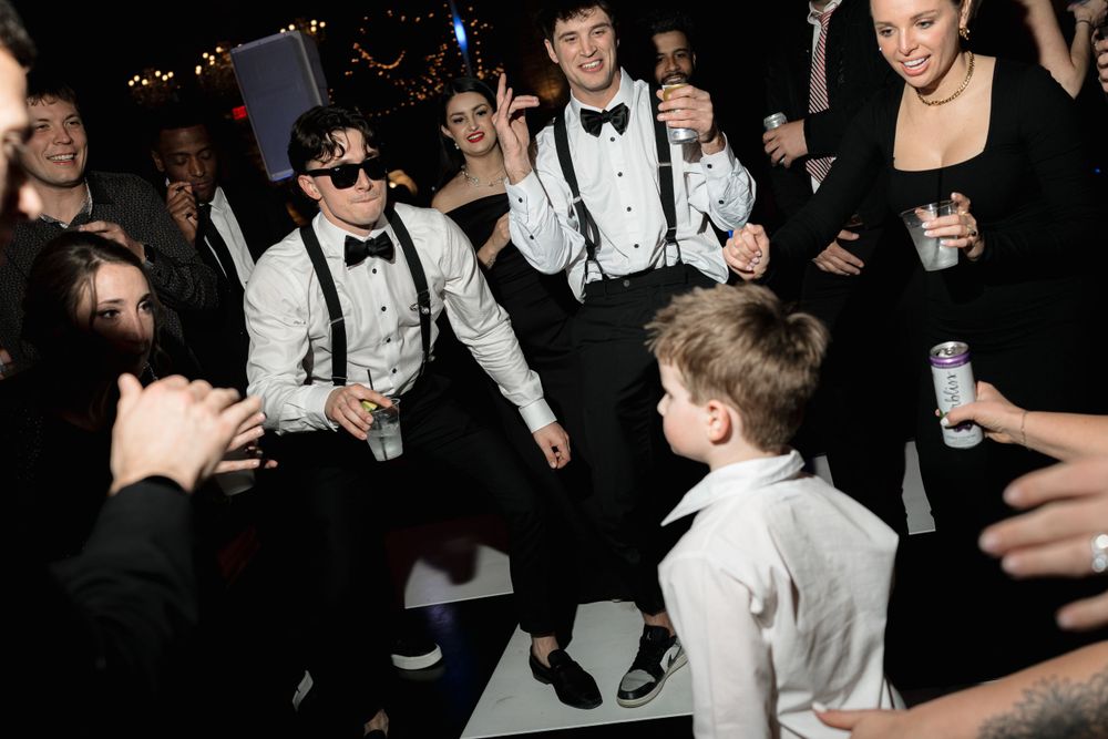 Energetic dancing and celebration on a dance floor at an elegant evening event.
