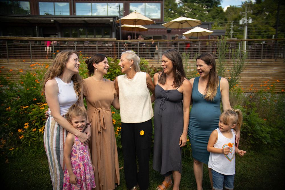 A cheerful group shares a candid moment while posing in a flowering garden.