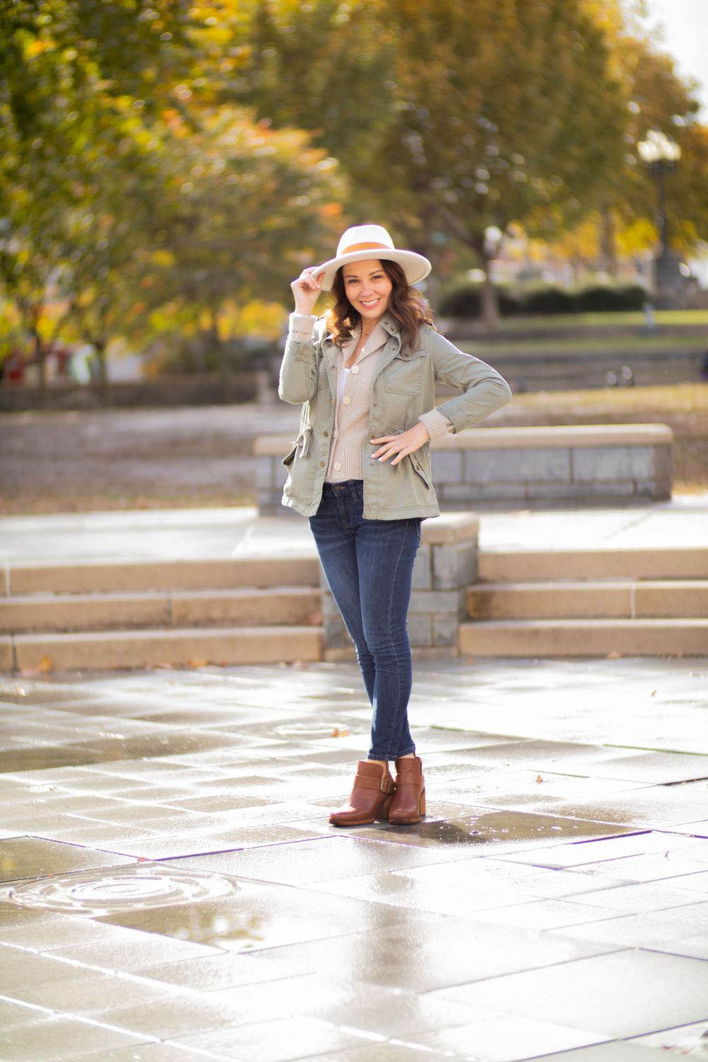 Casual autumn style with ankle boots, fedora hat and utility jacket on wet stone steps.