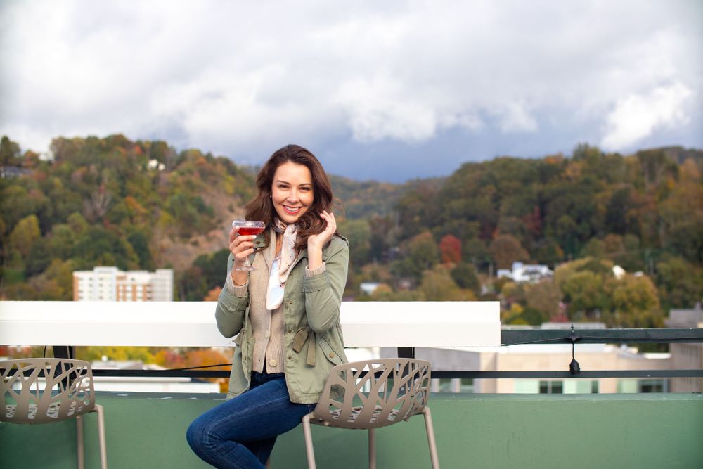 Autumn cityscape view from a rooftop terrace with fall foliage in the background.