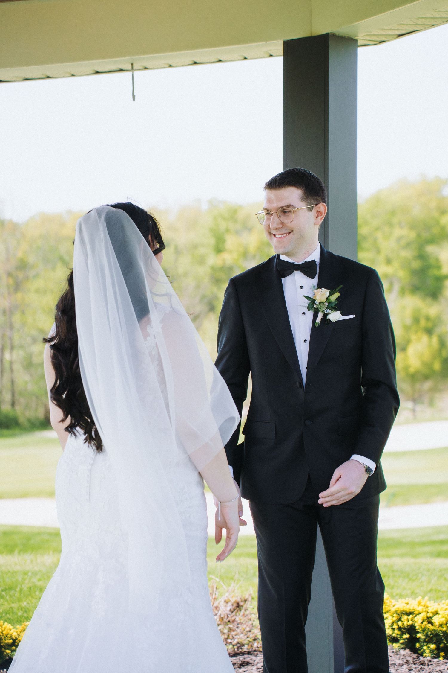 Wedding couple share their first look moment under covered outdoor area.