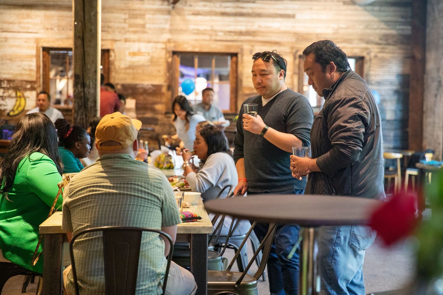 Casual dining scene in a rustic restaurant with exposed brick walls and industrial lighting overhead.