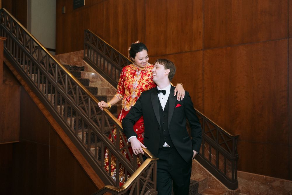Couples embrace during an elegant wedding reception in a wood-paneled venue.