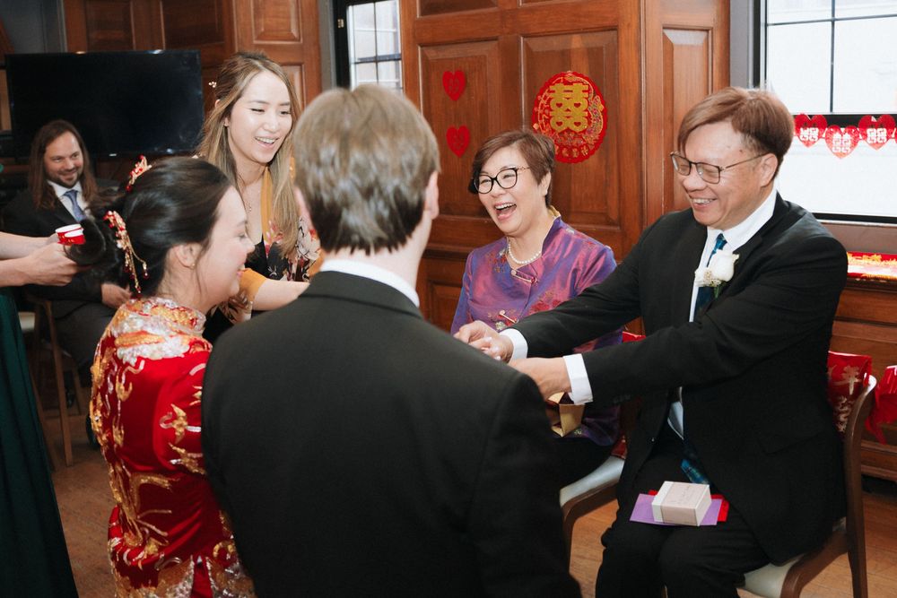 Wedding guests mingle in an elegant wood-paneled room during a reception.