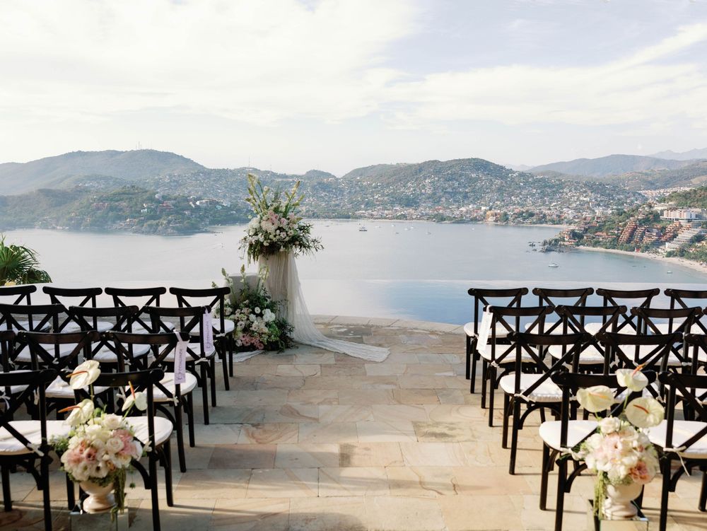 Wedding ceremony setup with black chairs overlooking a scenic mountain lake view.