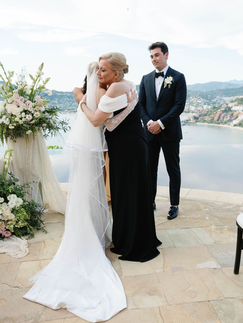 Wedding ceremony moment on scenic terrace overlooking mountain lake vista.