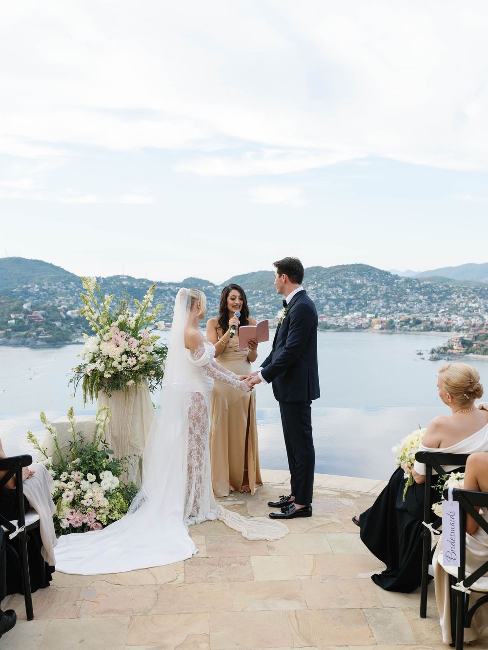 Wedding guests enjoying and laughing during ceremony in an outdoor courtyard.