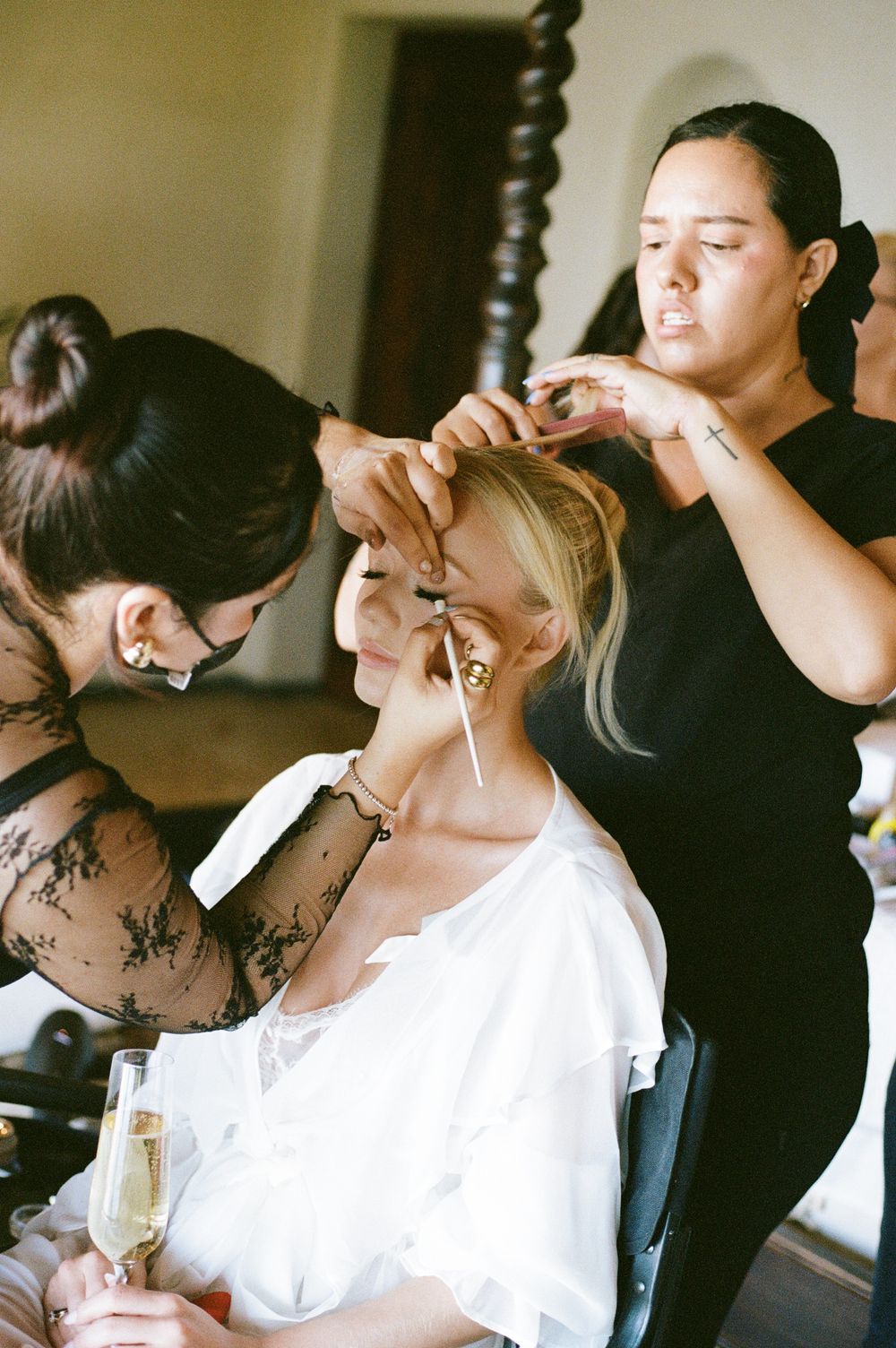 Wedding day preparation scene with styling tools and champagne in an elegant room.