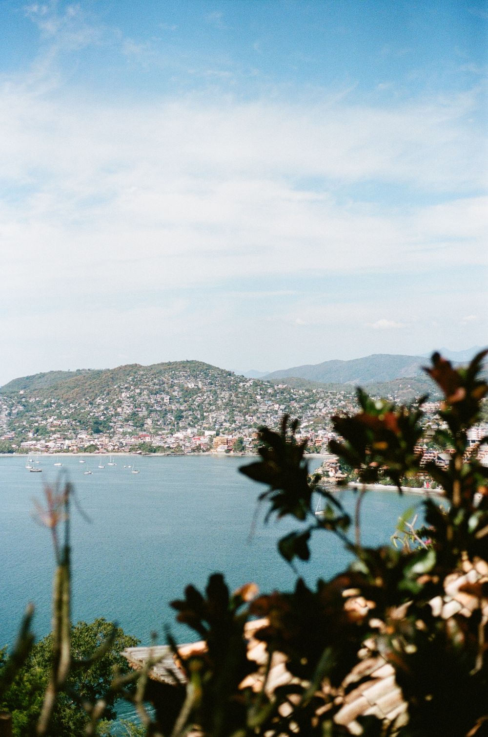 Coastal Mediterranean landscape with hillside homes overlooking a serene bay.