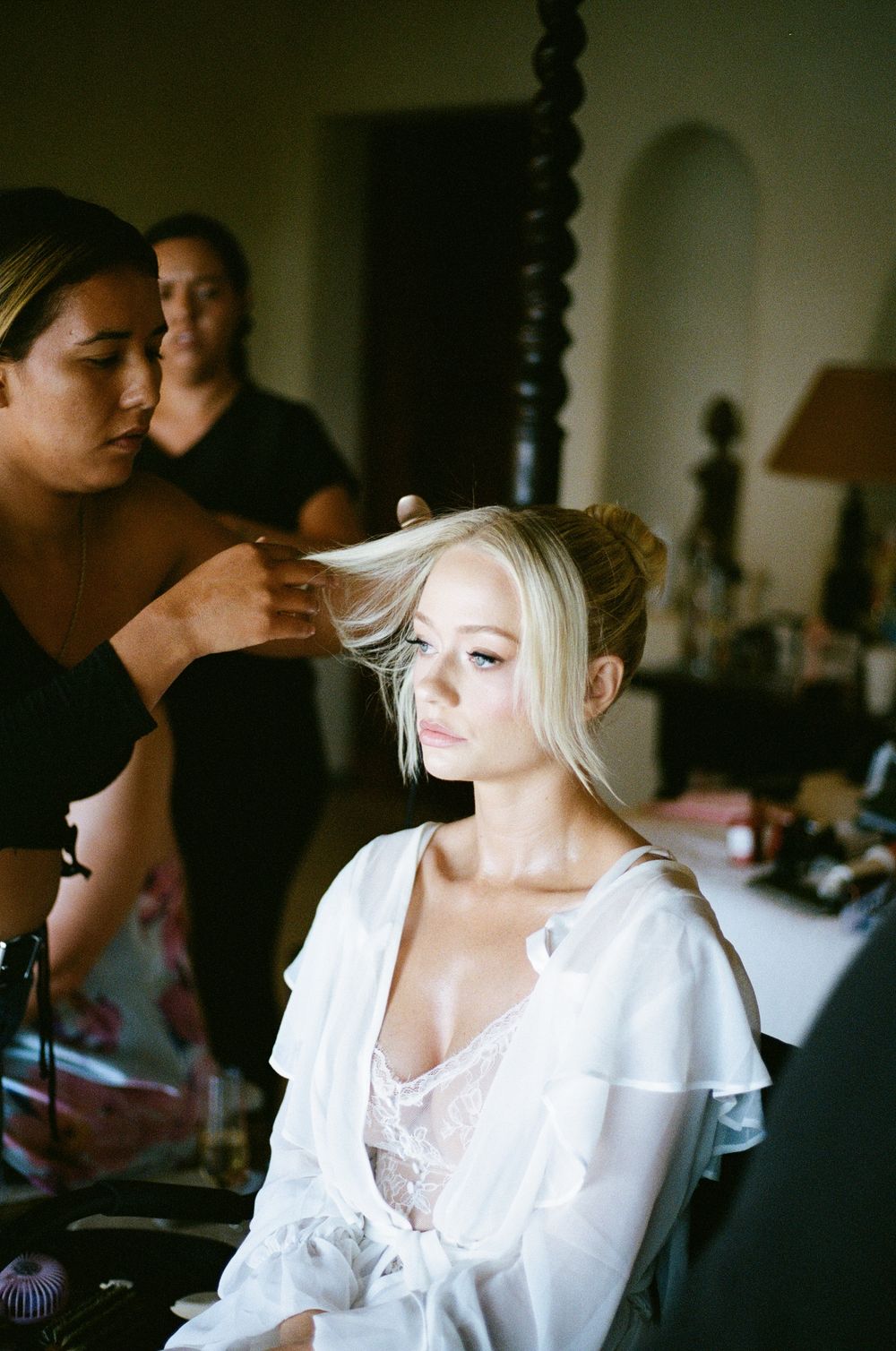 Behind-the-scenes wedding preparation in a softly lit room with styling equipment.