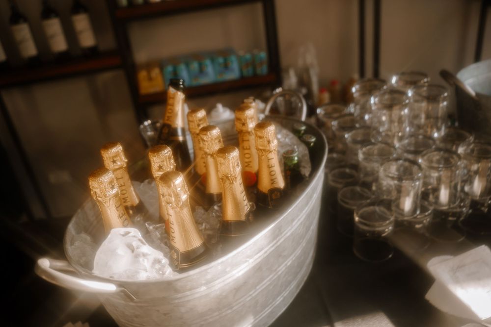 Chilled champagne bottles in an ice bucket with empty glasses ready for service.