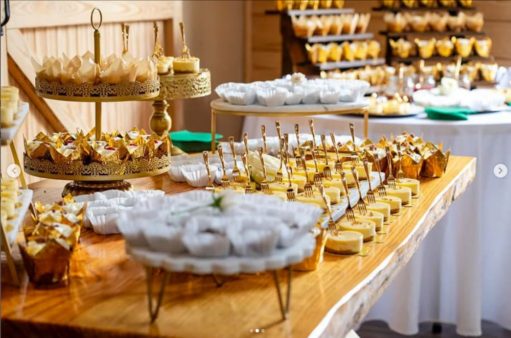 Elegant wedding reception dessert tables with gold stands and white serving plates display an array of sweet treats.