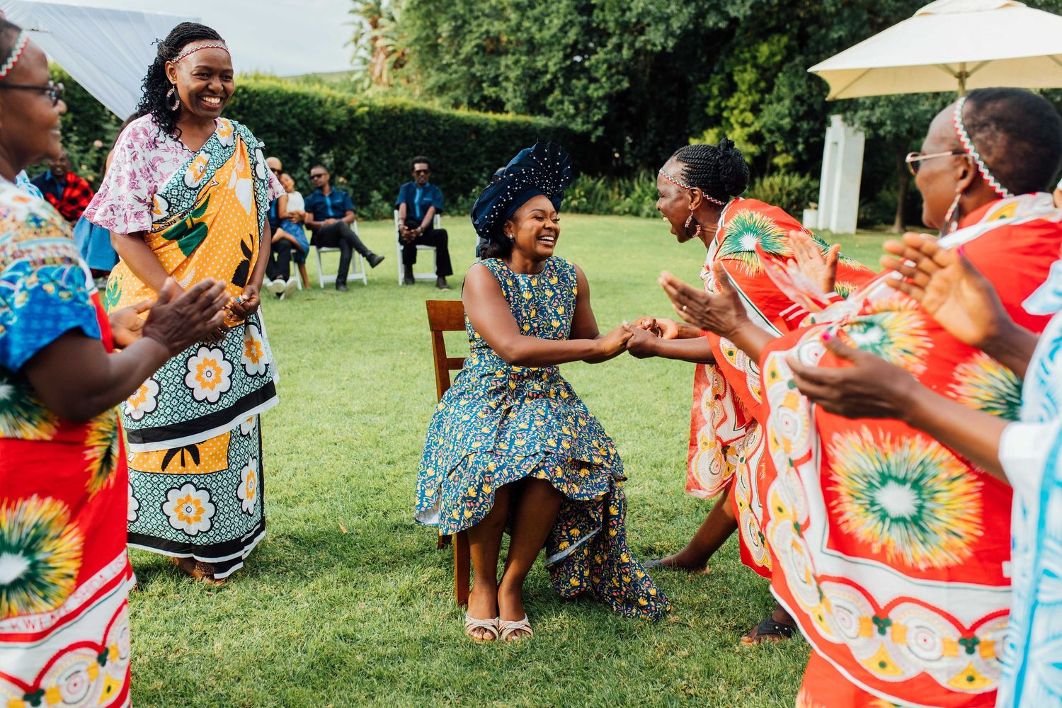 People dancing and celebrating outdoors on a sunny day during a festive cultural gathering.