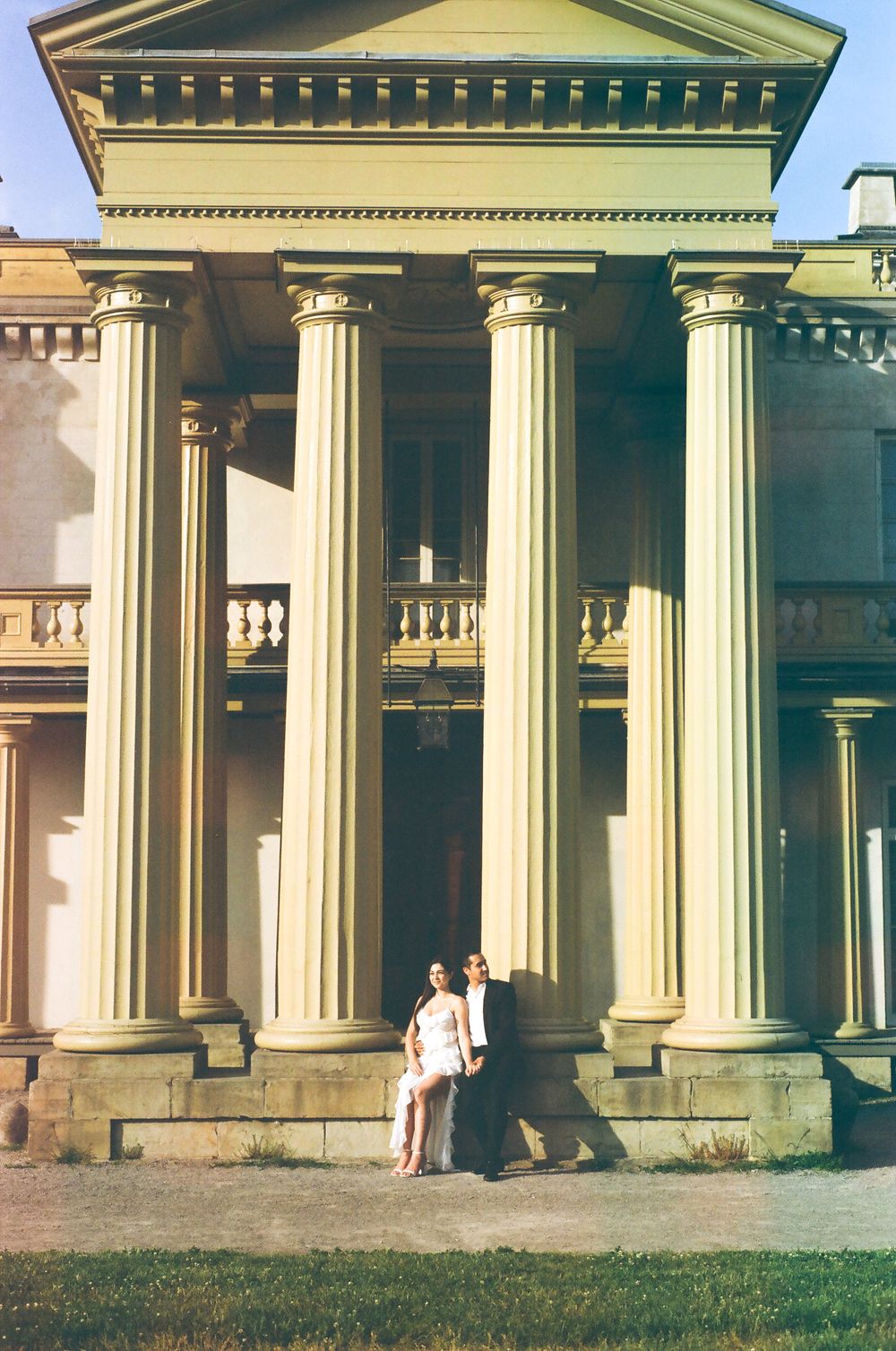 Classical architecture with grand columns and pediments creates an elegant backdrop in warm lighting.